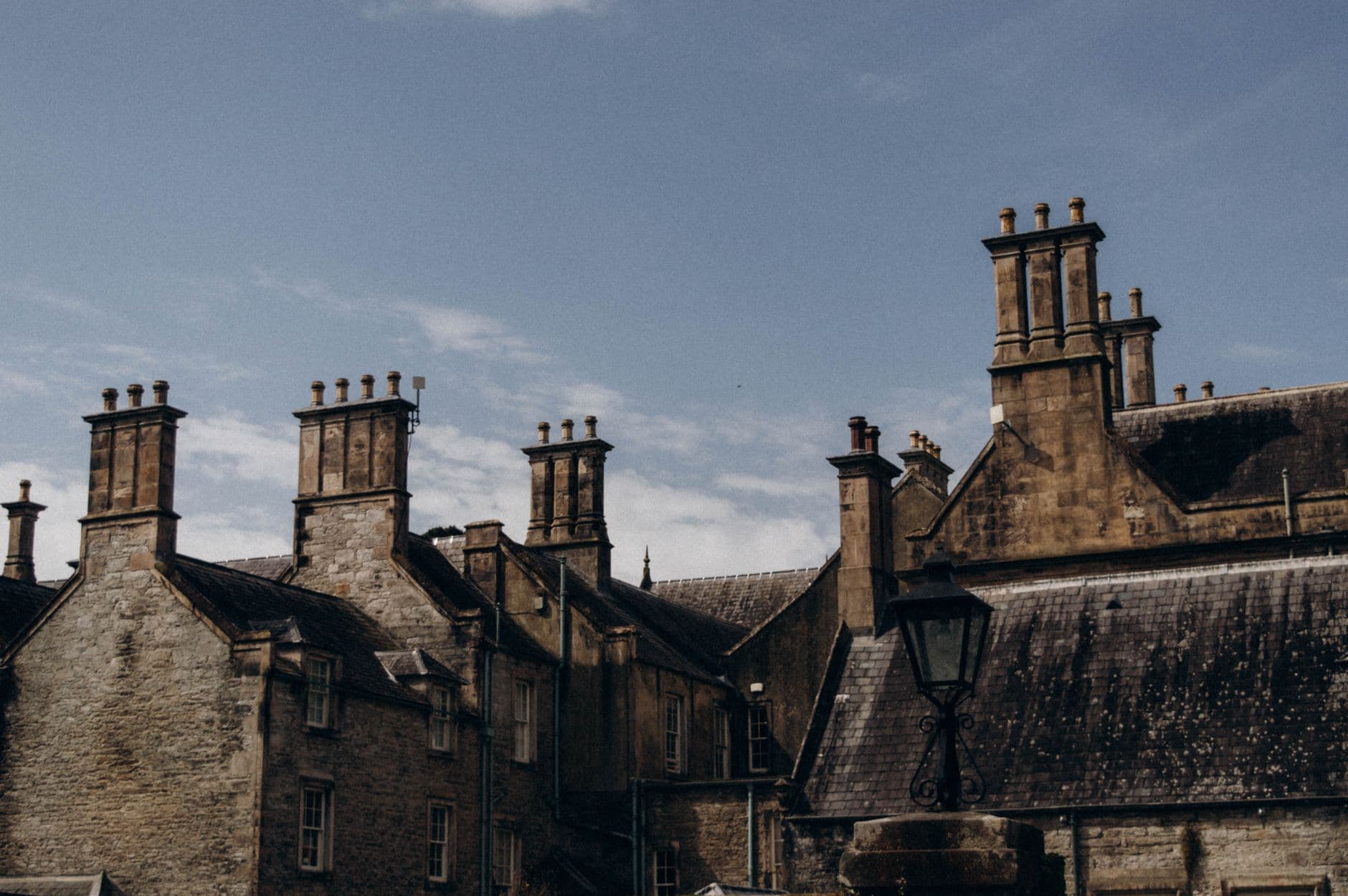 A captivating view of historic Gothic brick buildings with tall chimneys under a clear sky.